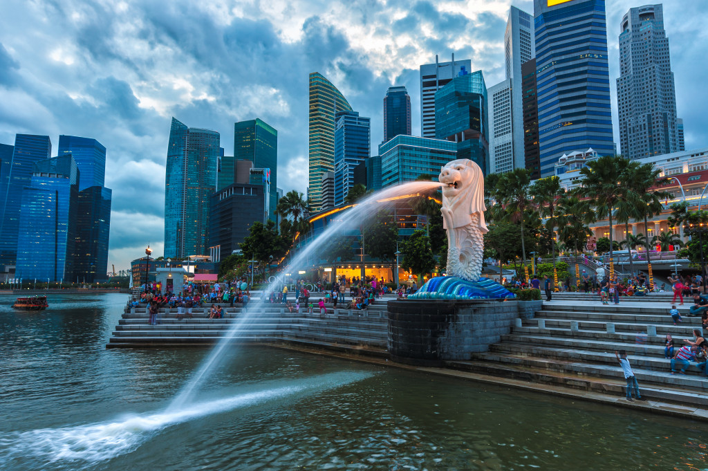 The Merlion fountain lit up at against the Singapore skyline.