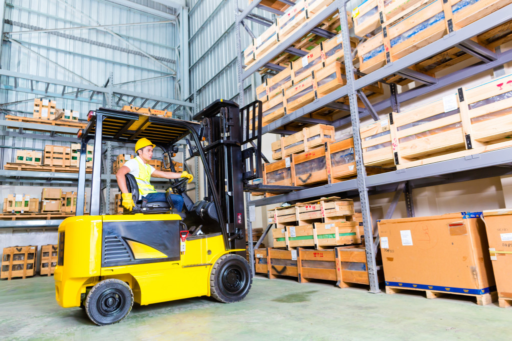a male forklift driver getting a palette from shelf