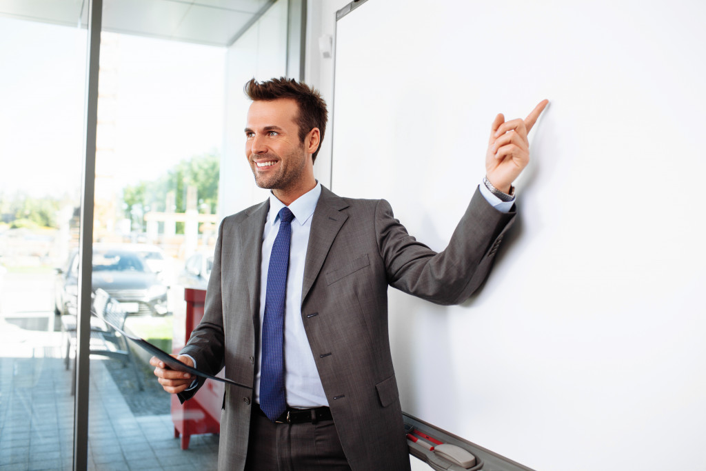 professional manager or professor pointing at whiteboard
