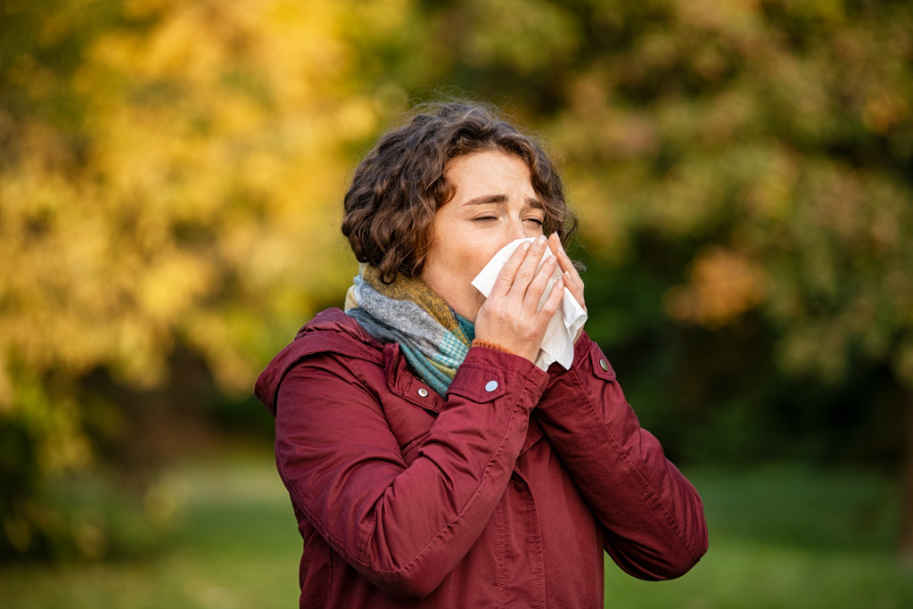 woman with sinusitis wiping her nose
