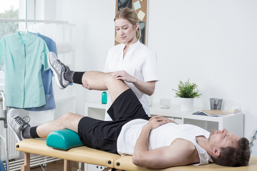 A female chiropractor rehabilitating a man's leg